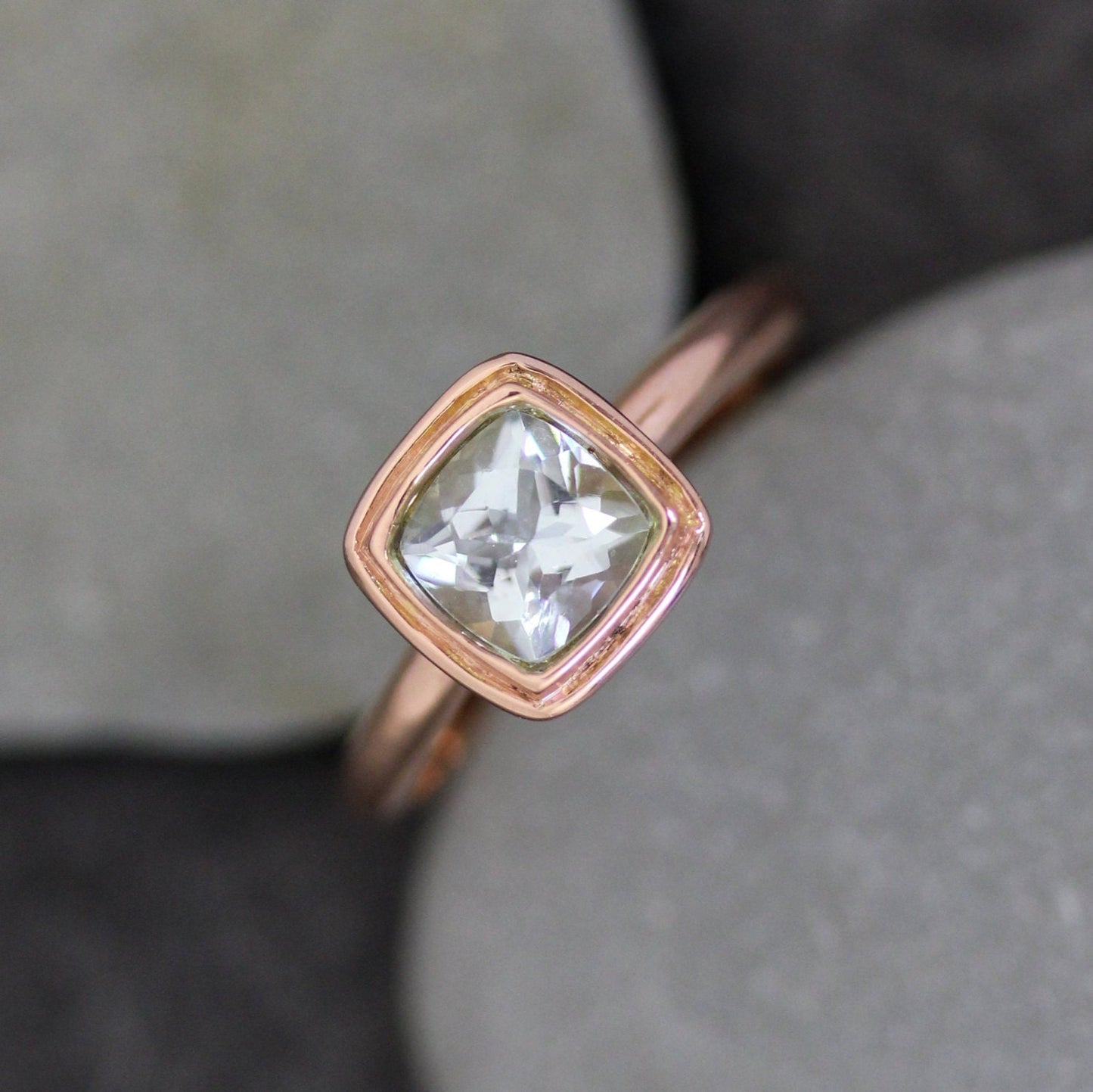 Cassin Jewelry's handmade Soft Blue Aquamarine Halo Ring in Recycled 14k Rose Gold with a white topaz stone.