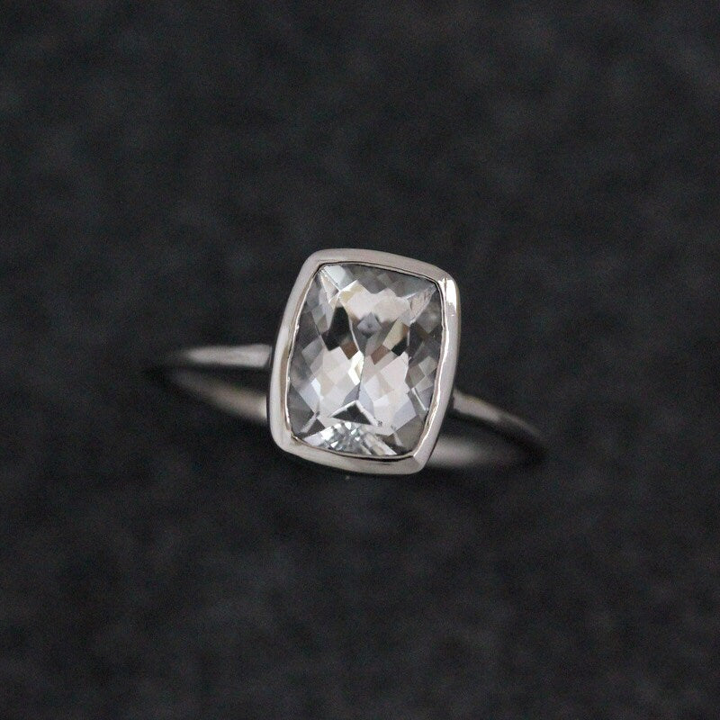 A Cassin Handmade White Topaz Engagement Ring with a square cut stone.