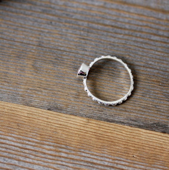 A handmade Morganite ring in Sterling Silver displayed on a wooden table.