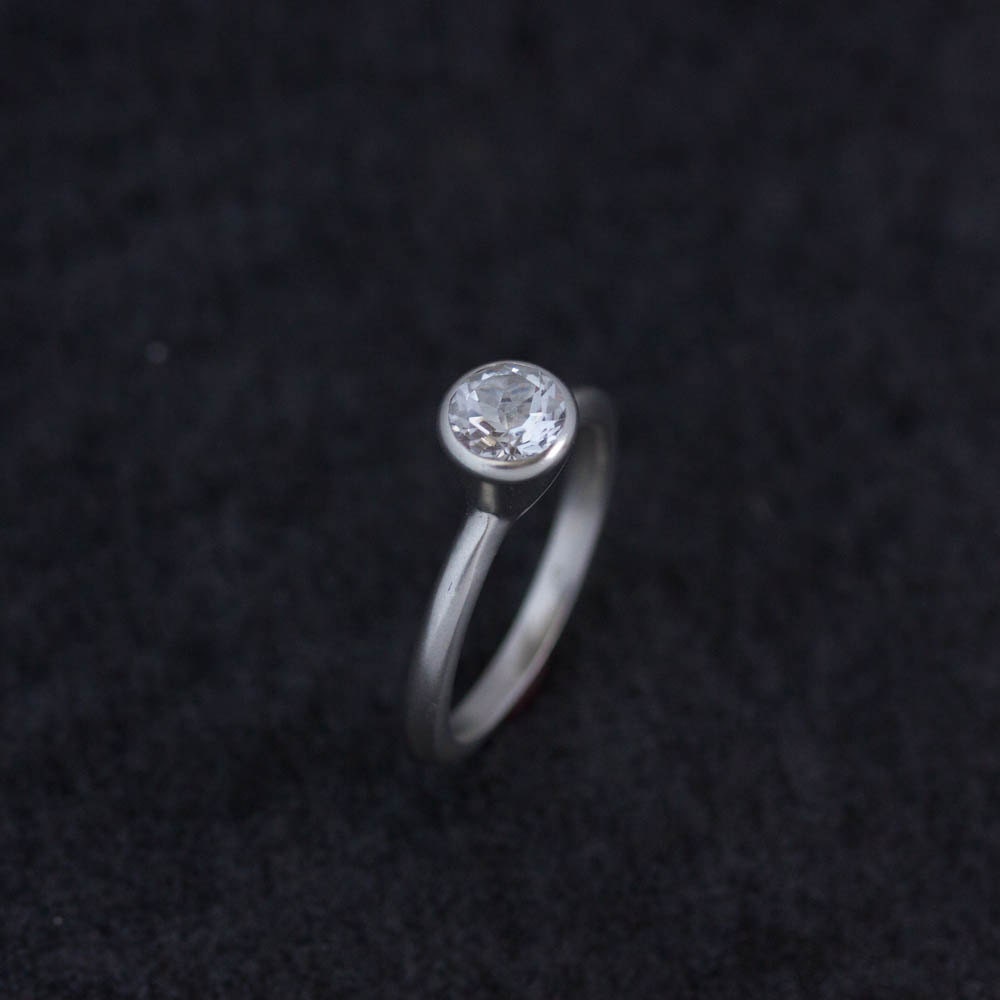 A Simple handmade engagement ring with a diamond in the center.