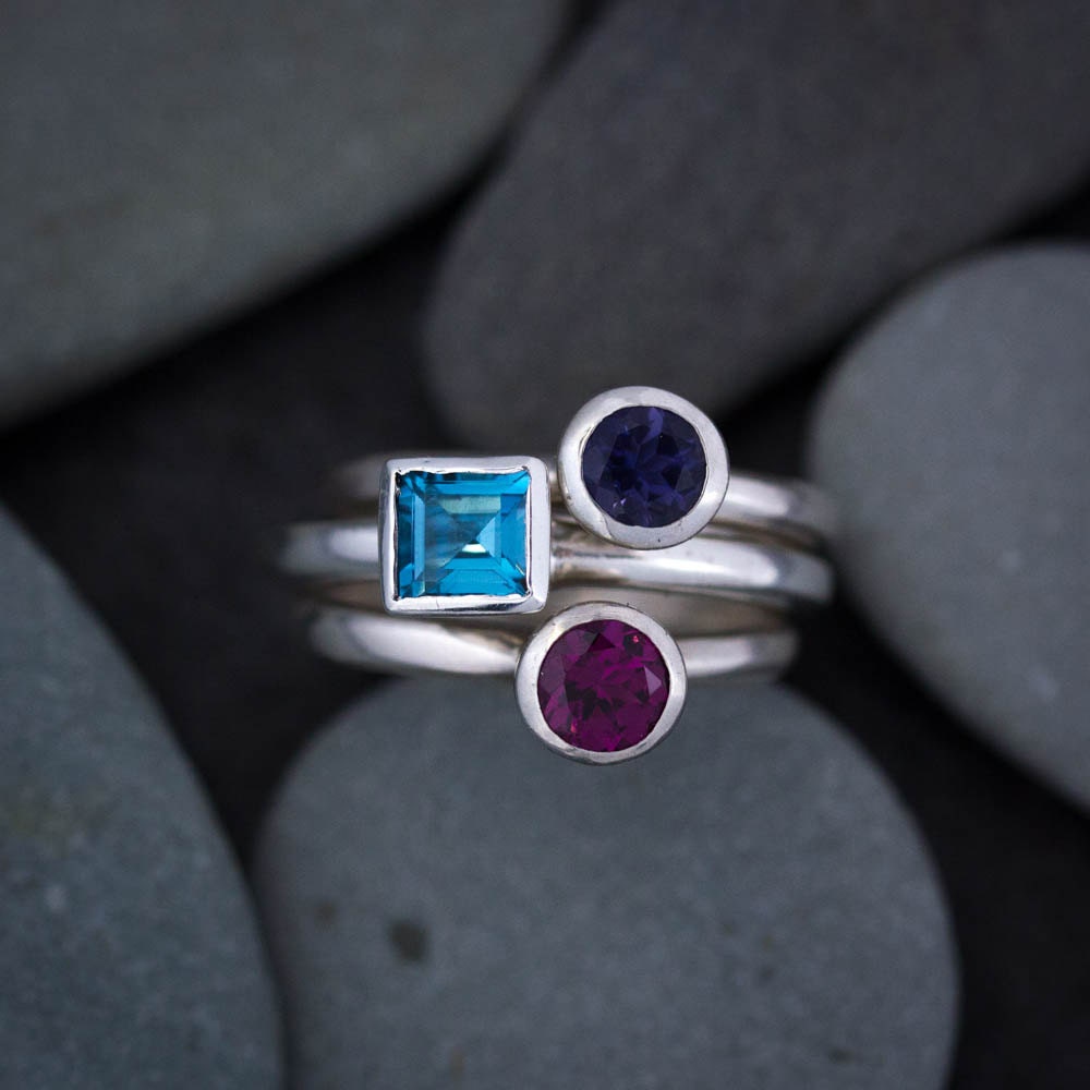 Handmade sterling silver rings with Square London Blue Topaz and purple sapphires available at Cassin Jewelry.