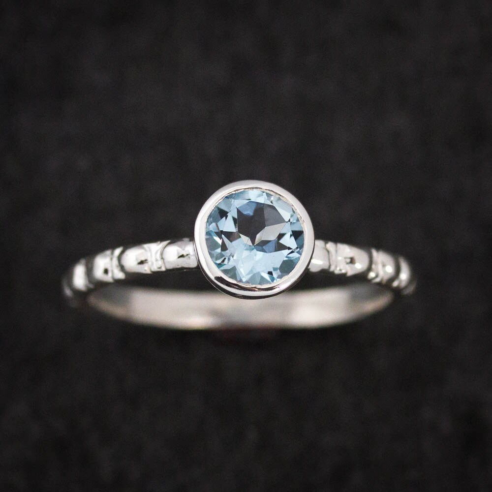 Handmade sterling silver ring with a round aquamarine stone.