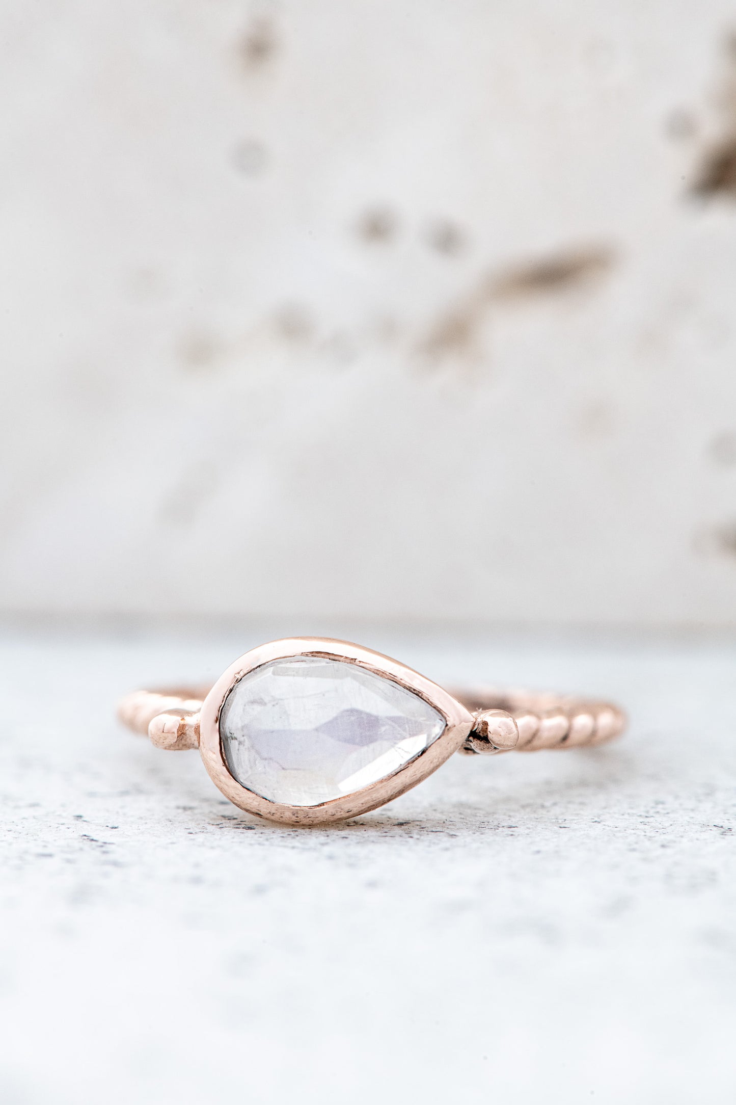 A handmade rose gold ring adorned with a stunning Pear Shaped Rainbow Moonstone.